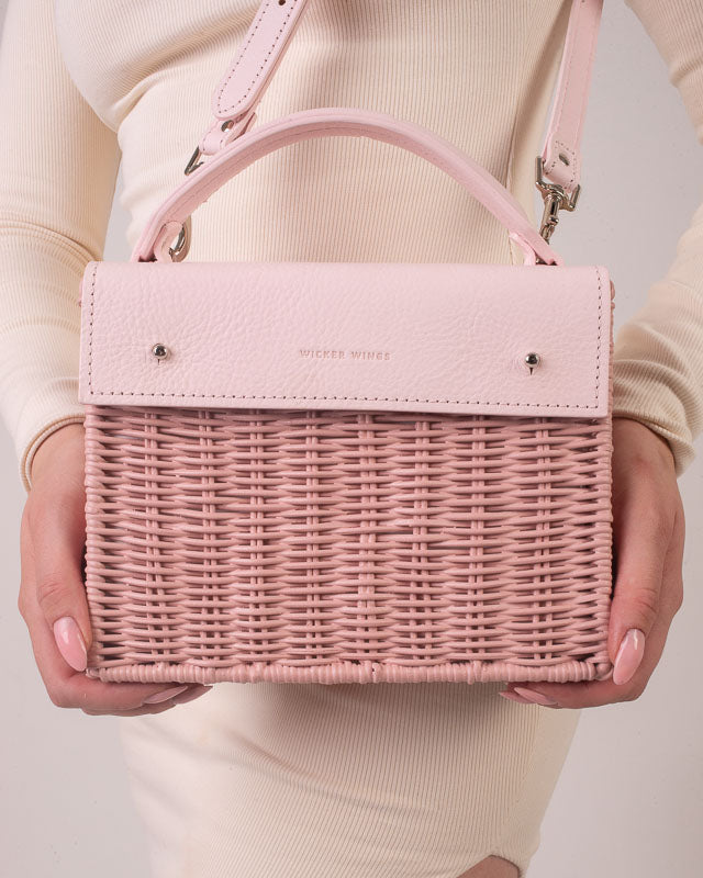 Wicker Wings Kuai Pink handwoven wicker bag, held by model