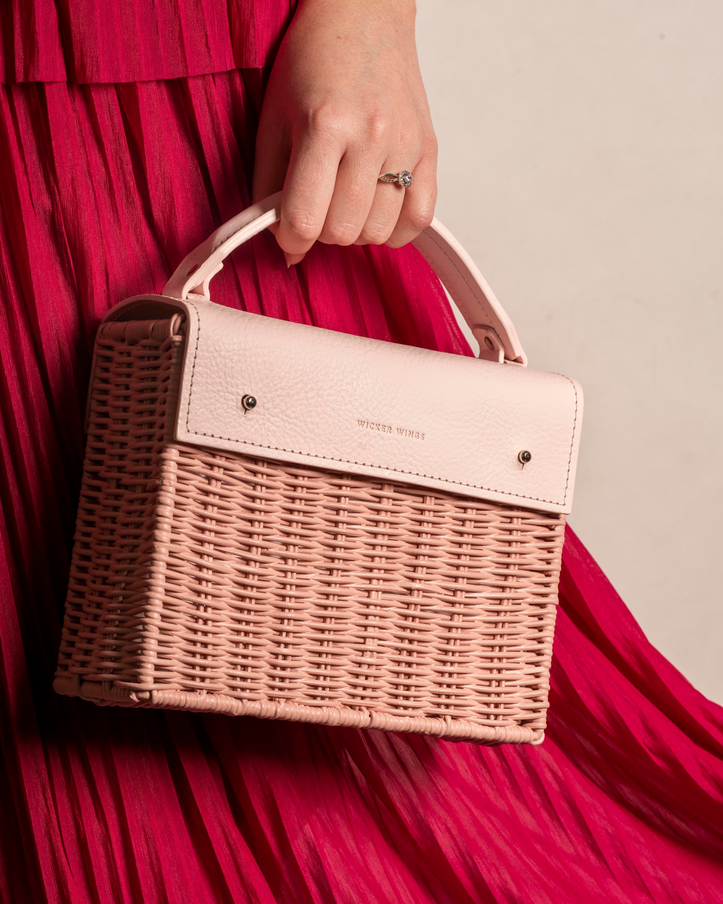 Wicker Wings Kuai Pink handwoven wicker bag, held by model