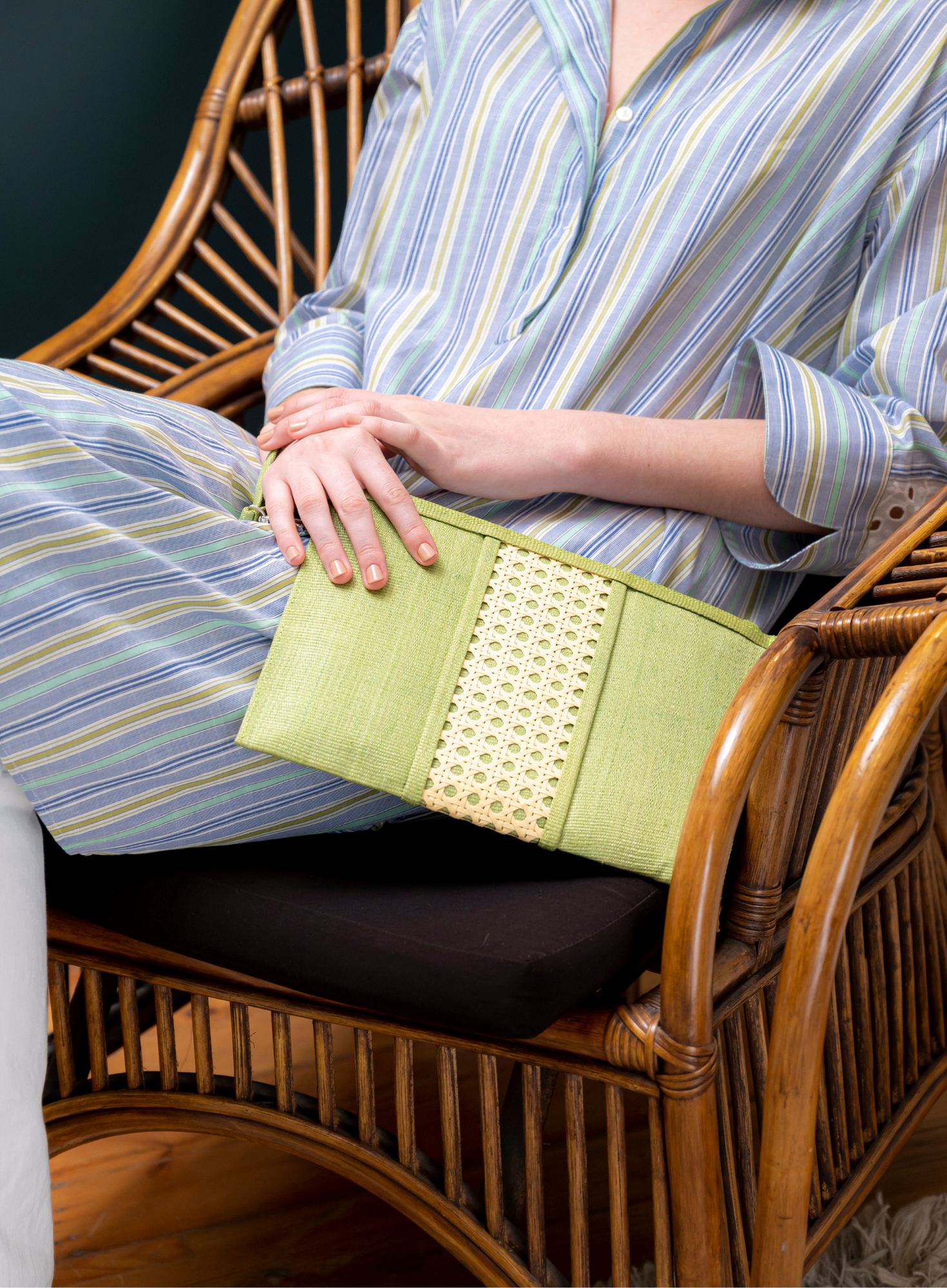 A seated model holds the GUSTOKO Isla Lime handwoven pouch.