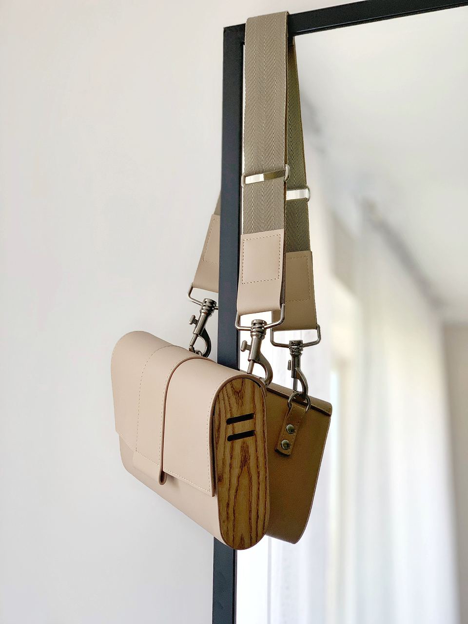Kate Chi Wooden Walls Bag hung on a mirror.