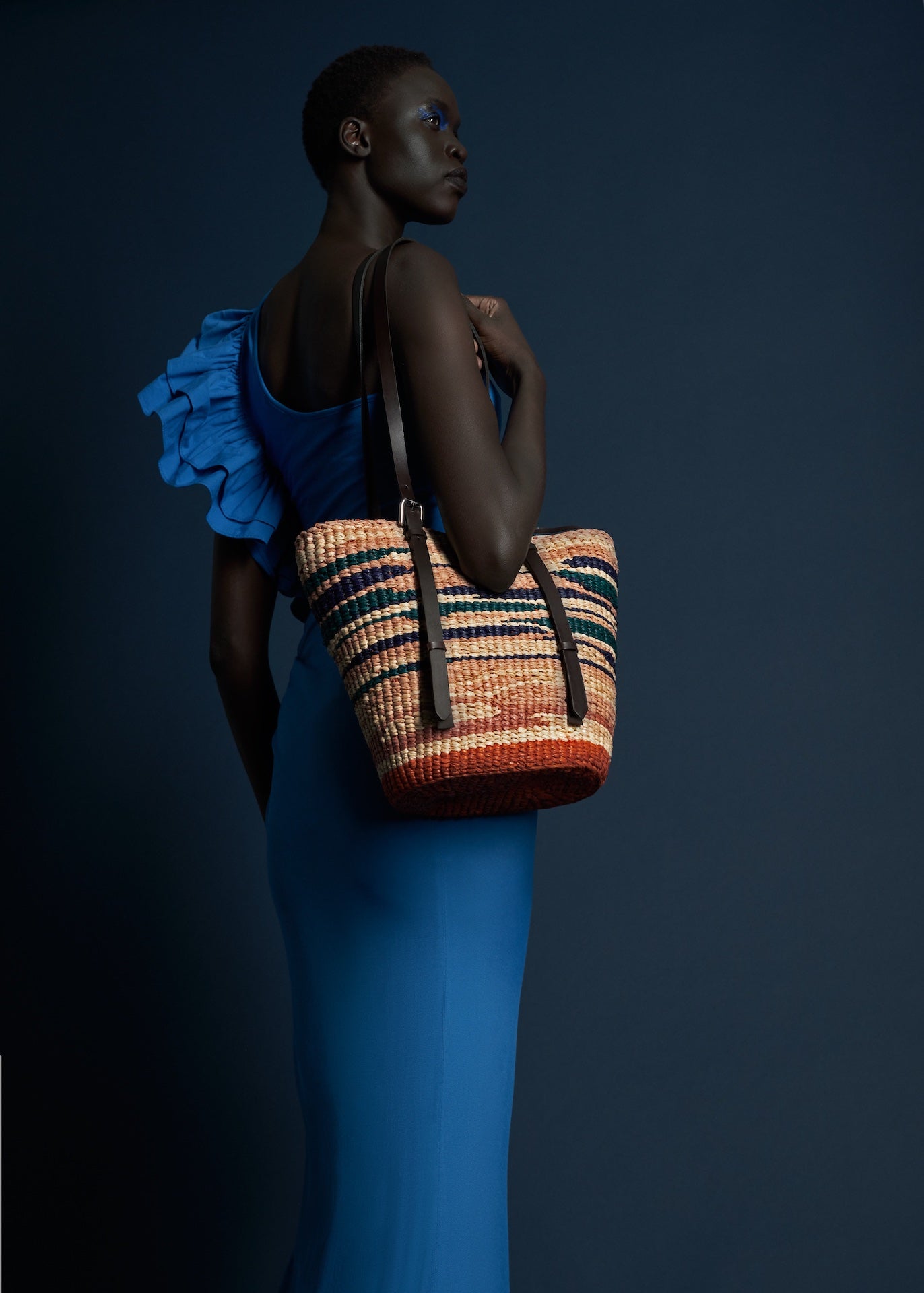The A A K S handcrafted raffia tie dye tote bag, on model's shoulder